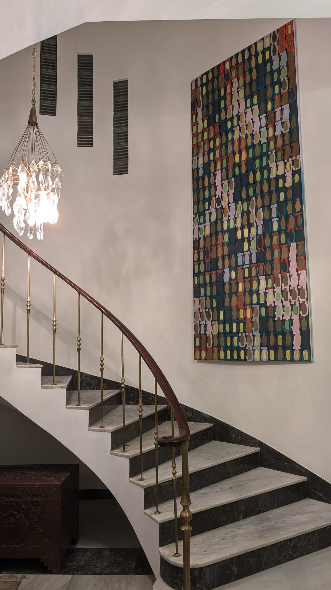 Installation view: the painting hung above a staircase.