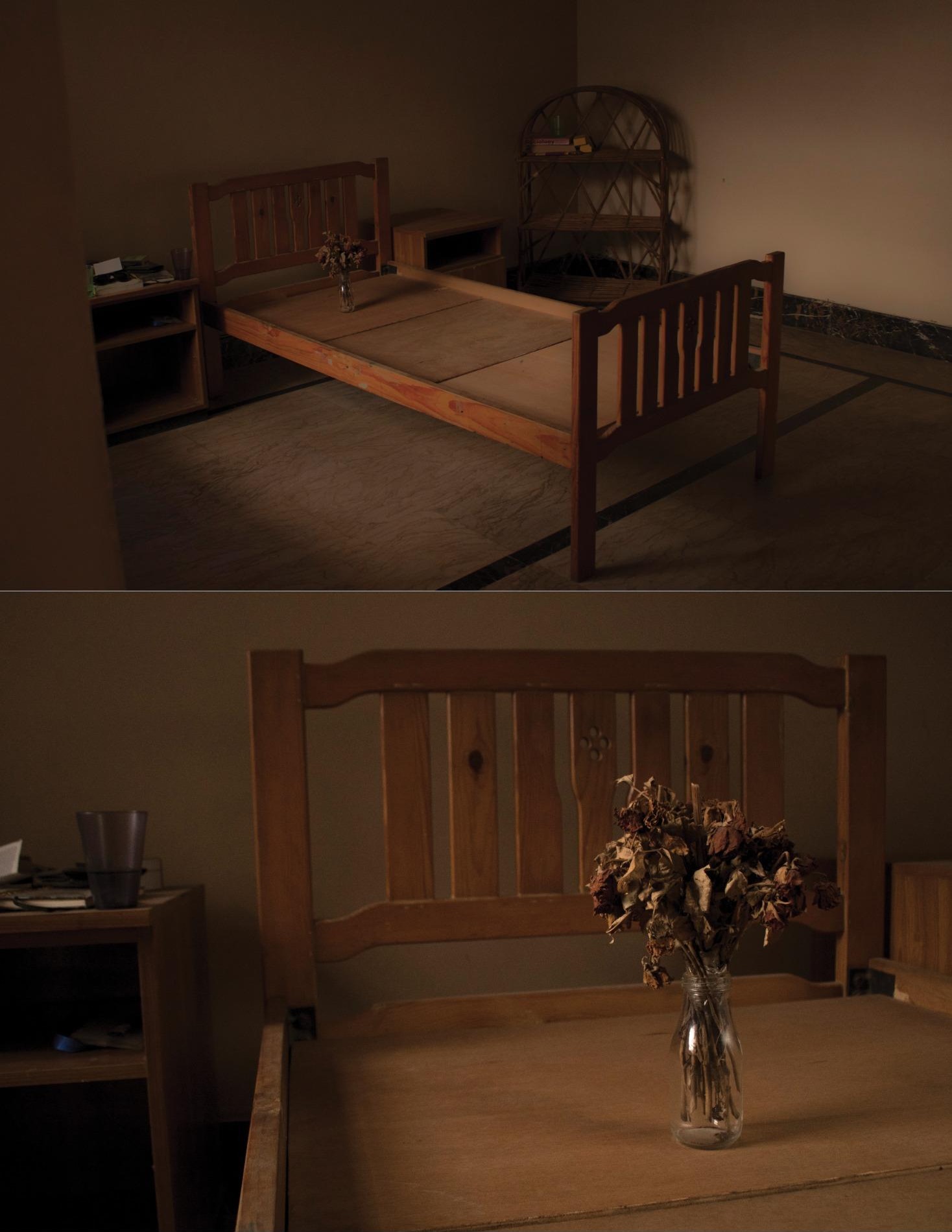 A bare wooden bed frame in a dim room, and a close view of dried flowers in a glass on the same bed